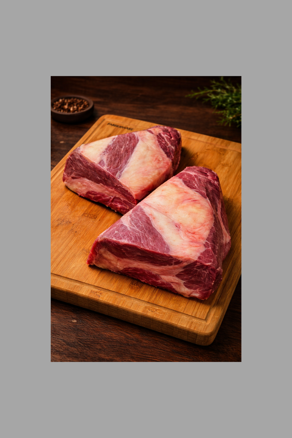 Raw beef brisket cuts on wooden cutting board