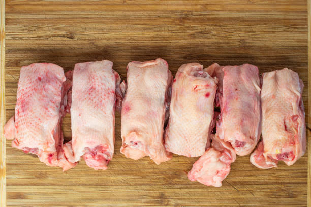 Raw chicken backs bundle on a wooden board, multiple pieces