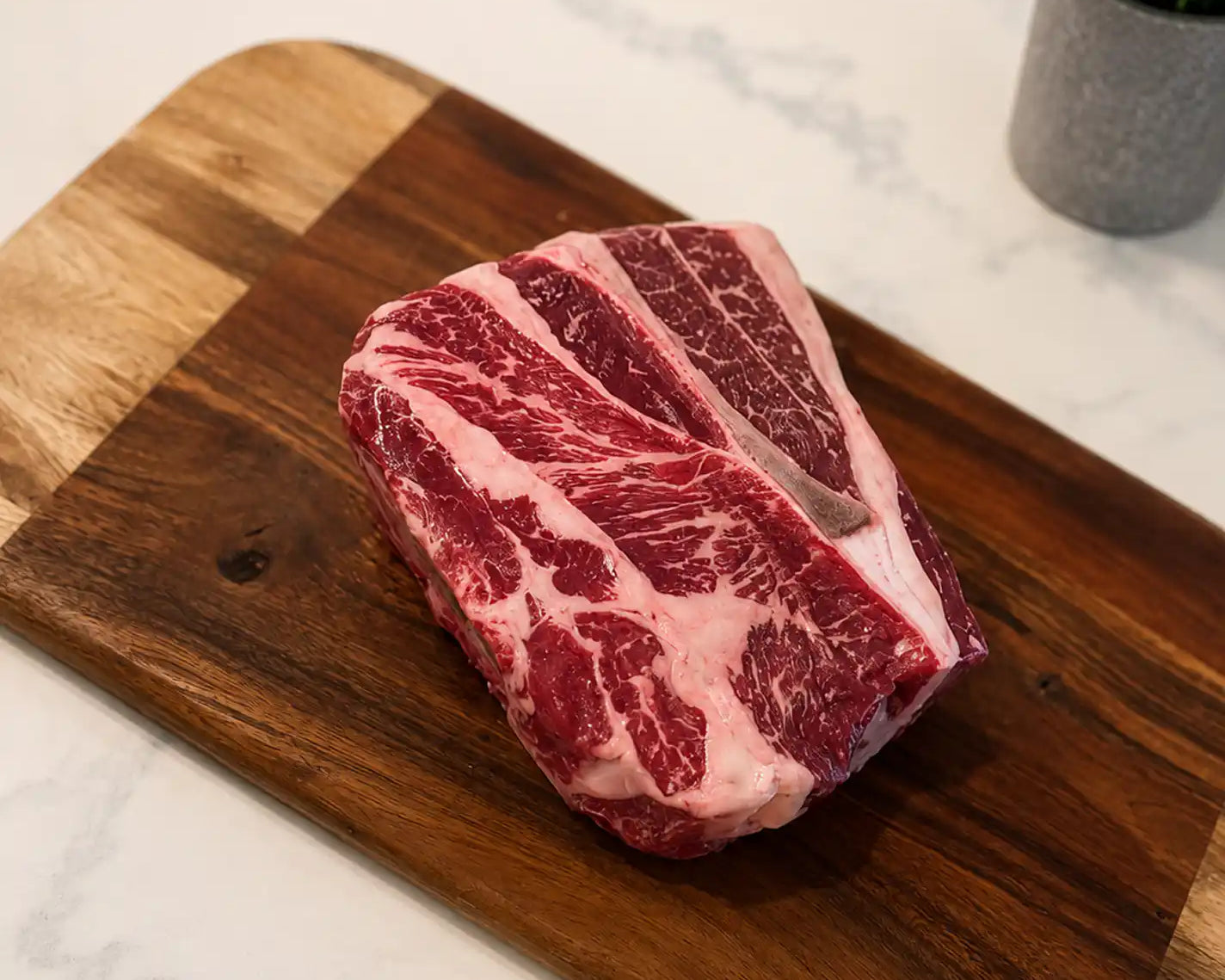 Raw chuck roast with prominent marbling on dark red meat