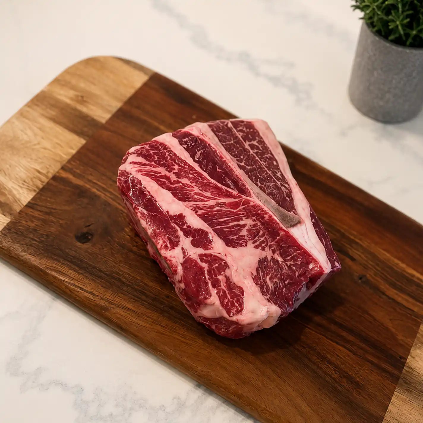 Raw chuck roast with prominent marbling on dark red meat