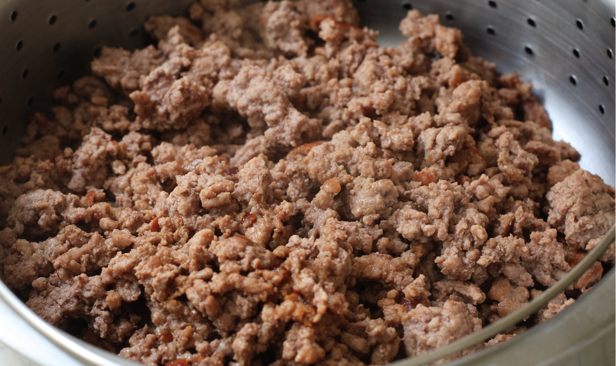 Brown ground pork sausage in a colander, crumbly texture