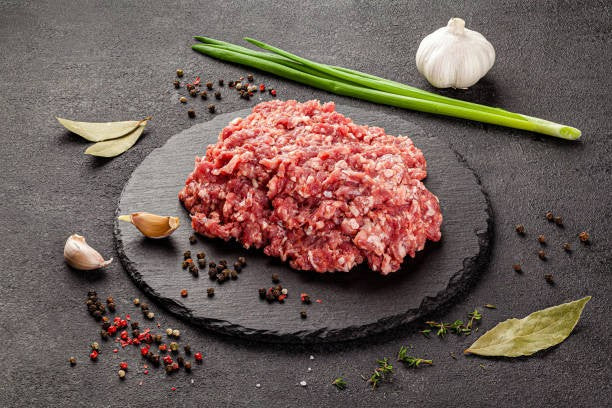 Raw ground lamb mound with visible fat and texture, ready for cooking