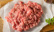 Raw ground pork mince on parchment with parsley