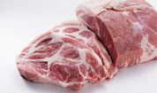 Raw pork butt cuts with visible fat marbling, pale pink and white