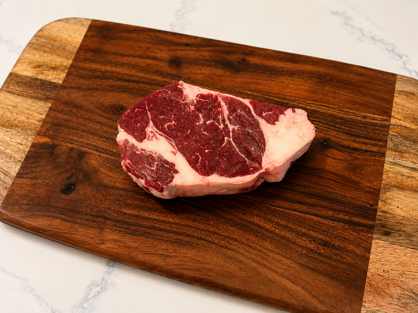Raw ribeye steak with visible fat marbling and red meat