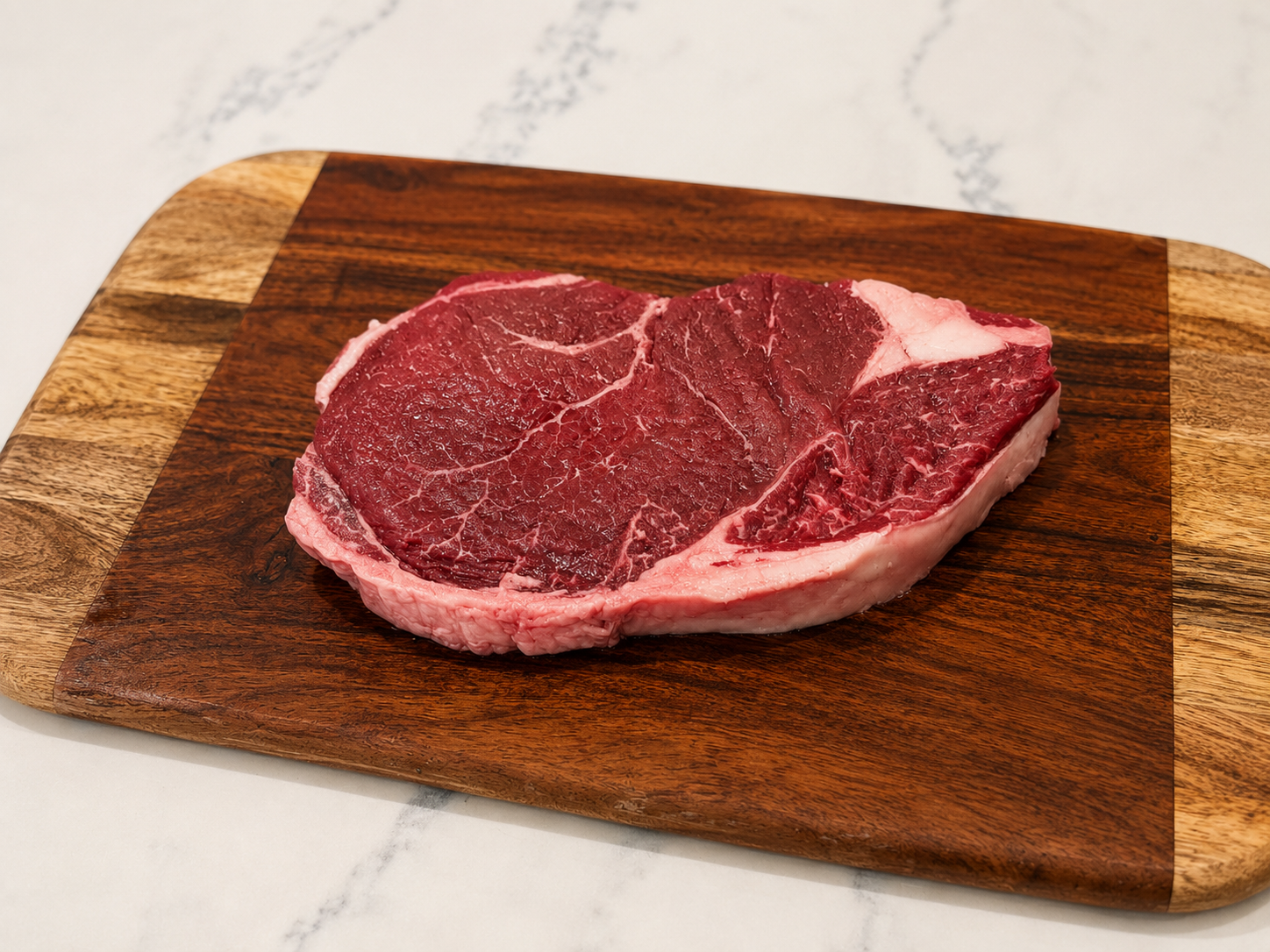 Raw sirloin steak on wooden board, red meat with white fat edge